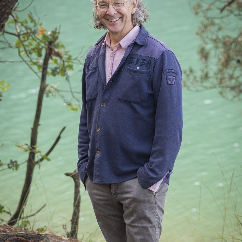 Owen staand bij blauwe meer